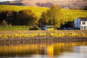 Lakeline branded single decker bus passing Hollingworth Lake on route 458 to Rochdale